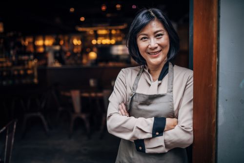 Taiwanese business owner of a coffee shop standing outside of her business