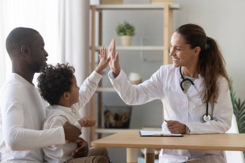 african little boy gives high five to female doctor