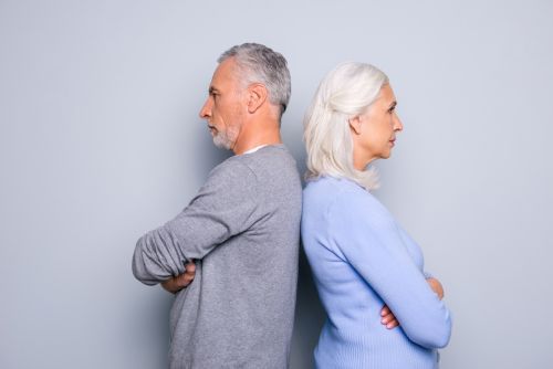 Concept of Gray Divorce -misunderstanding and communicative problem between two senior people, they are standing back to back, isolated on grey background