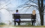 A couple sitting on opposite sides of the bench