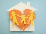 Paper family over torn heart in a house